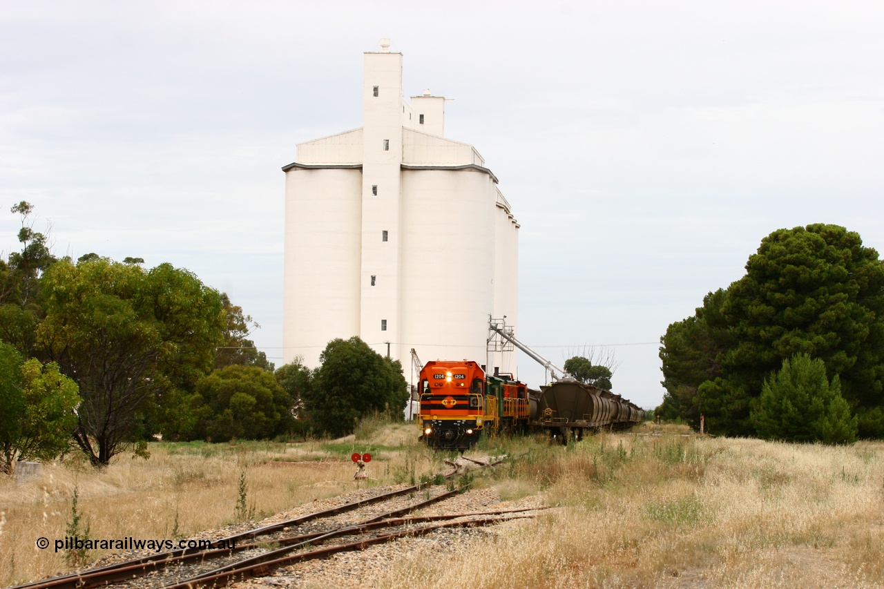 060110 2202
Yeelanna, yard overview as ARG 1200 class unit 1204, a Clyde Engineering EMD model G12C serial 65-428, originally built for the WAGR as the final unit of fourteen A class locomotives in 1965 and sent to the Eyre Peninsula in July 2004 stands with a rake of waggons into the grain siding with the 5 ton crane also visible as the locos are cut off with the remainder of the train holding the mainline. Off to the right is the former triangle. [url=https://goo.gl/maps/1JetzWBTGAw]Approx. location of image[/url].
Keywords: 1200-class;1204;Clyde-Engineering-Granville-NSW;EMD;G12C;65-428;A-class;A1514;