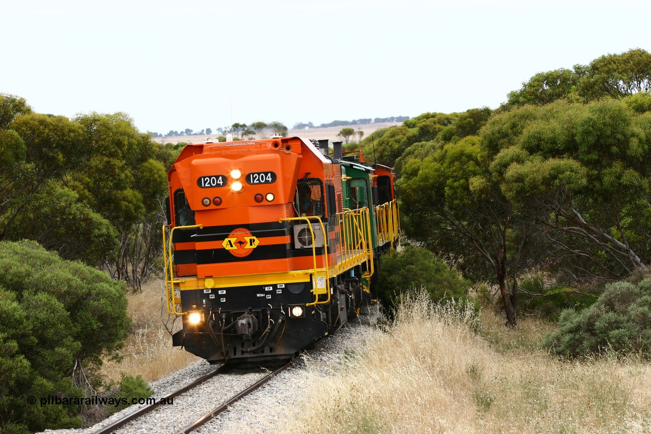 060110 2211
On the curve near the 85 km between Yeelanna and Karkoo, ARG 1200 class unit 1204, a Clyde Engineering EMD model G12C serial 65-428, originally built for the WAGR as the final unit of fourteen A class locomotives in 1965 and sent to the Eyre Peninsula in July 2004 leads an empty grain train. [url=https://goo.gl/maps/7kwfXBE6nS12]Approx. location of image[/url].
Keywords: 1200-class;1204;Clyde-Engineering-Granville-NSW;EMD;G12C;65-428;A-class;A1514;