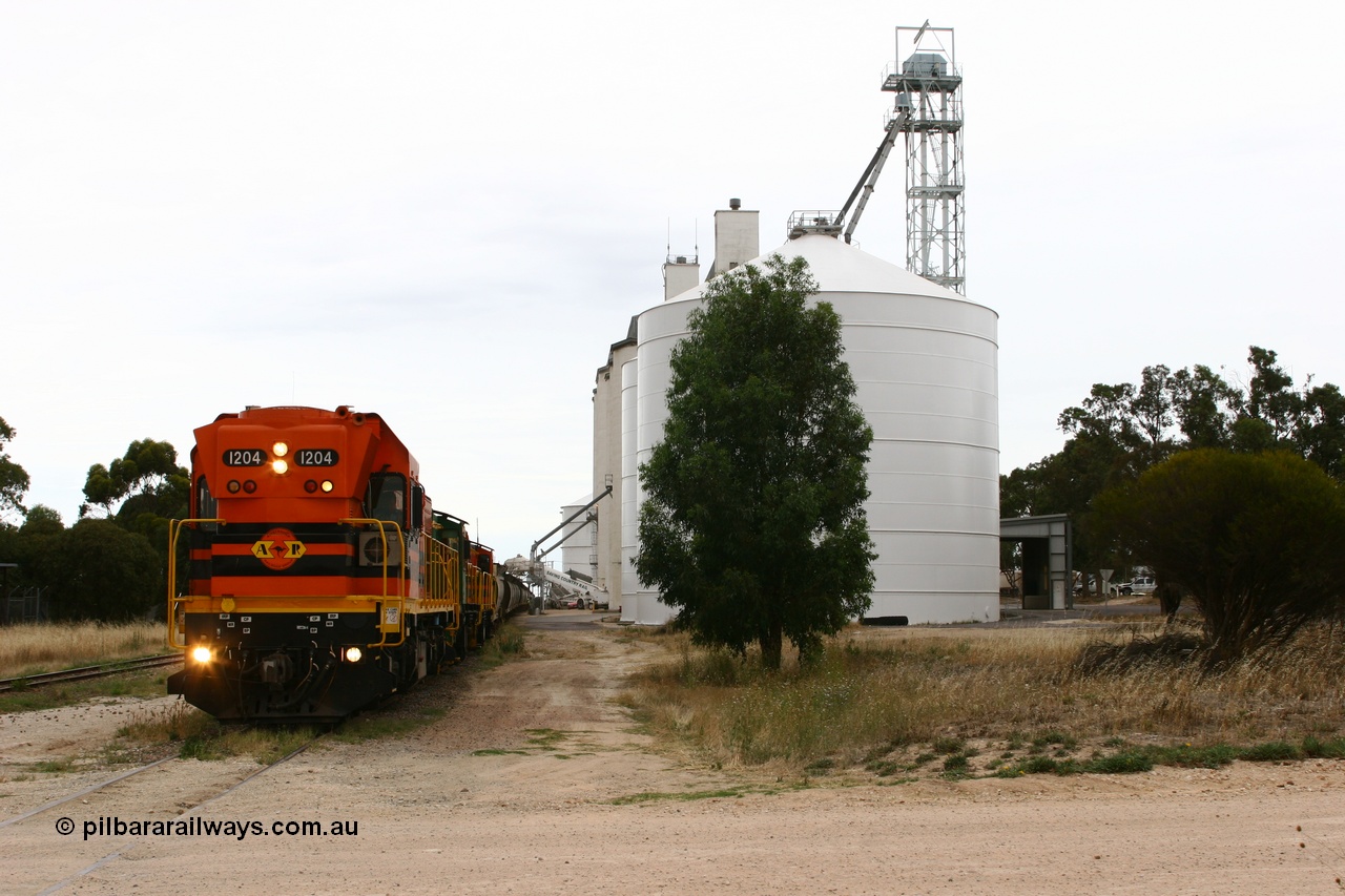 060110 2240
Lock, grain train loading underway behind ARG 1200 class unit 1204, a Clyde Engineering EMD model G12C serial 65-428, originally built for the WAGR as the final unit of fourteen A class locomotives in 1965 and sent to the Eyre Peninsula in July 2004 and two 830 class AE Goodwin built ALCo model DL531 units 842 serial 84140 ex SAR broad gauge and to Eyre Peninsula in October 1987, and 851 serial 84137 new to Eyre Peninsula in 1962. An Ascom silo complex is closest to camera. [url=https://goo.gl/maps/epTNTP7PARy]Approx. location of image[/url].
Keywords: 1200-class;1204;Clyde-Engineering-Granville-NSW;EMD;G12C;65-428;A-class;A1514;