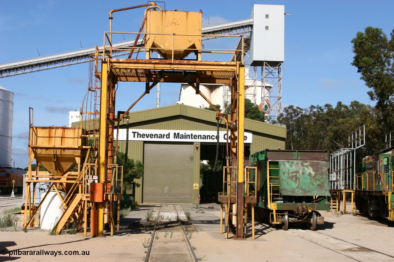 060113 2453
Thevenard Maintenance Centre overview, sanding tower in front of workshop, ENH type hopper waggon. Empty train 6DD3 sneaks beside the no longer rail served grain silos at left. 13th January 2006.
