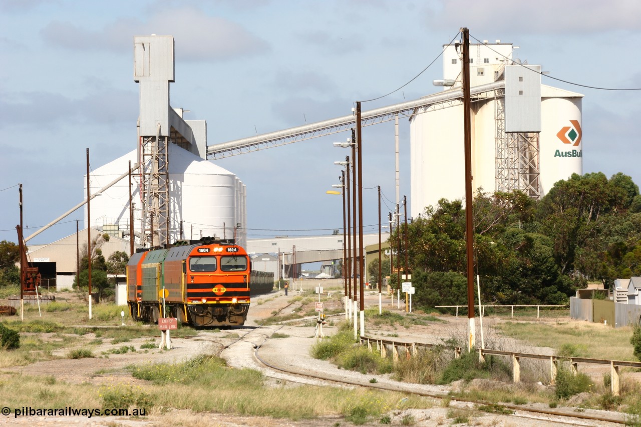 060113 2461
Thevenard, narrow gauge loco 1604 with a fresh crew depart the yard with empty train 6DD3, 1604 leads a triple consist of Clyde Engineering built EMD JL22C model 1600 / NJ class combination of 1604 serial 71-731 and originally NJ 4, NJ 3 serial 71-730 and 1601 serial 71-728 the original class leader NJ 1, all three units started on the Central Australia Railway in 1971 and were transferred to the Eyre Peninsula in 1981. 1604 and 1601 both renumbered in 2004. A roll-by is also being conducted by an outgoing crew member. 13th January 2006.
Keywords: 1600-class;1604;Clyde-Engineering-Granville-NSW;EMD;JL22C;71-731;NJ-class;NJ4;