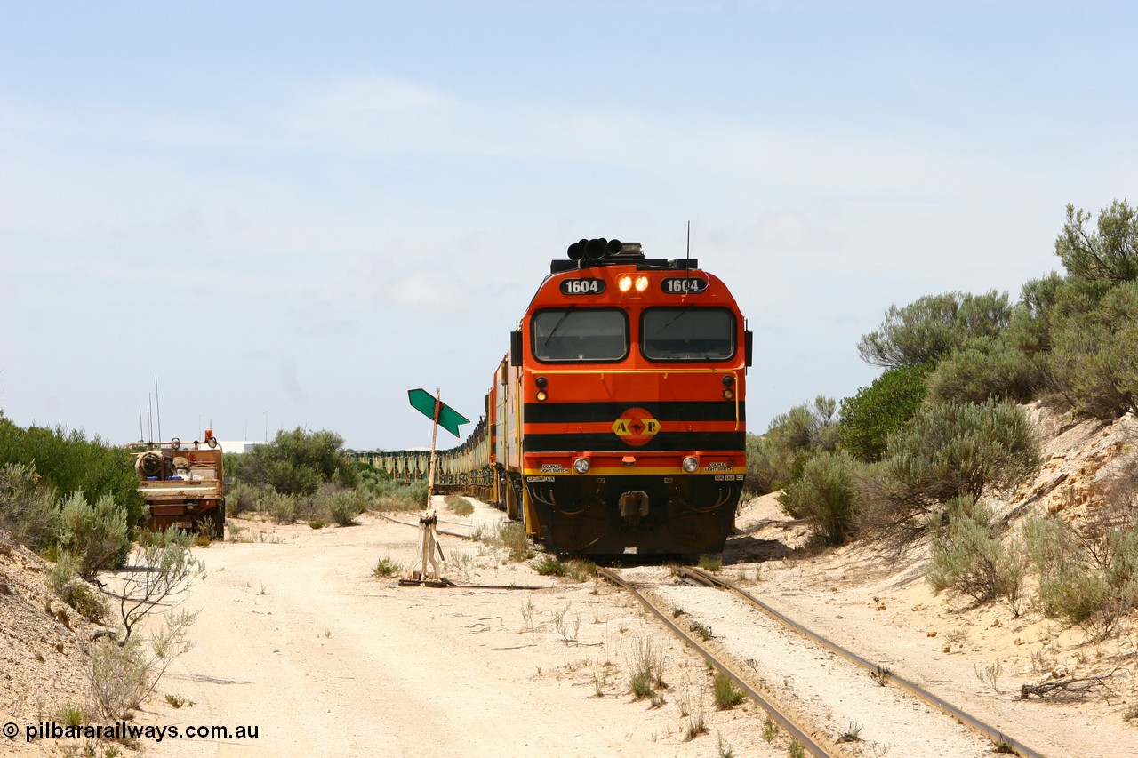 060113 2503
Kevin, view looking from the Penong end of Kevin with the goods siding points and indicator besides narrow gauge loco 1604 as it leads NJ 3 and 1601 with empty train 6DD3 as they reverse around the triangle to position the train for loading back on the mainline to Thevenard. 13th January 2006.
Keywords: 1600-class;1604;Clyde-Engineering-Granville-NSW;EMD;JL22C;71-731;NJ-class;NJ4;