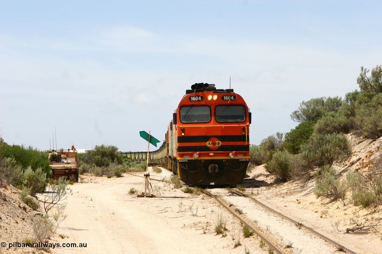 060113 2504
Kevin, view looking from the Penong end of Kevin with the goods siding points and indicator besides narrow gauge loco 1604 as it leads NJ 3 and 1601 with empty train 6DD3 as they reverse around the triangle to position the train for loading back on the mainline to Thevenard. 13th January 2006.
Keywords: 1600-class;1604;Clyde-Engineering-Granville-NSW;EMD;JL22C;71-731;NJ-class;NJ4;