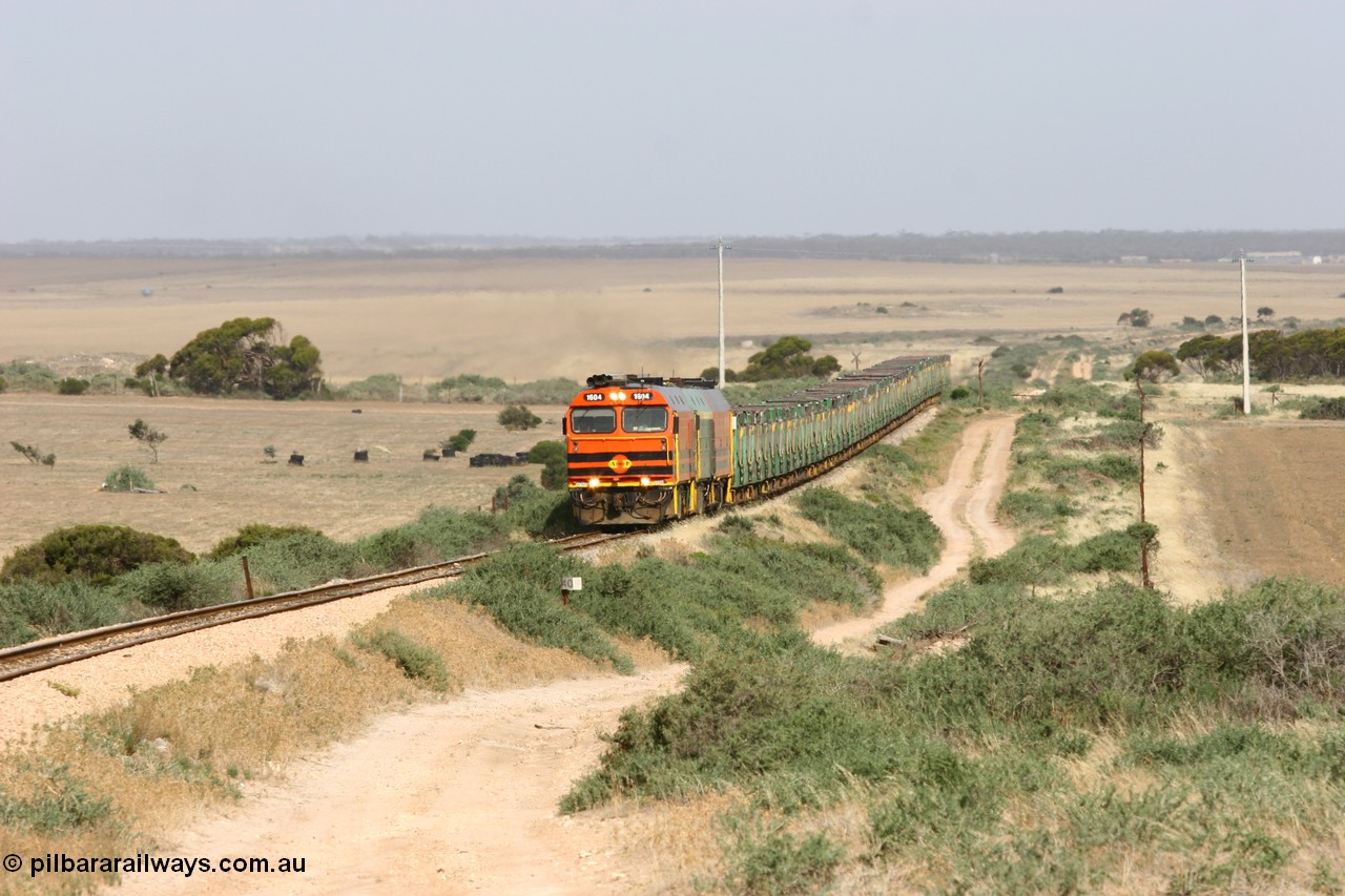 060113 2575
Ceduna, or Denial Bay area, empty gypsum train 6DD5 blasts up hill at the 440 km, crossing Carpenter Corner Rd with power from triple 1600/NJ class units 1604, NJ 3 and 1601. 1604 in Australian Railroad Group livery is a Clyde Engineering built EMD JL22C model serial 71-731, originally built as NJ class NJ 4. [url=https://goo.gl/maps/ULA2PjjKh6nhwHTdA]Location approximation[/url]. 13th January 2006.
Keywords: 1600-class;1604;Clyde-Engineering-Granville-NSW;EMD;JL22C;71-731;NJ-class;NJ4;