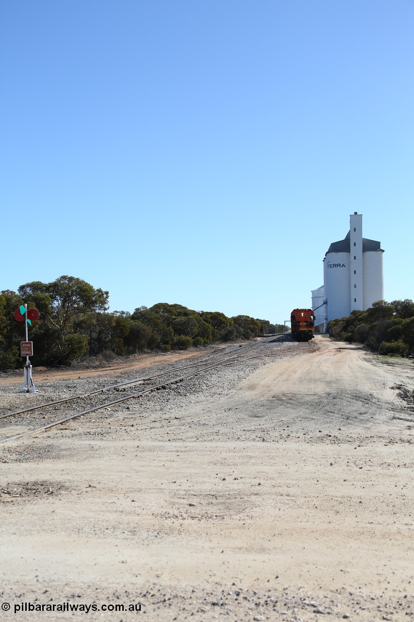 130703 0161
Murdinga, overview of the station yard looking north, siding point lever and indicator, Mallee style shelter train control building in the far distance on the left beside train, grain train loading on the siding, eight cell concrete grain silo complex with Ascom single cell behind it. [url=https://goo.gl/maps/LShPNnU33Qbmc1879]Geo location[/url]. 3rd July 2013.
