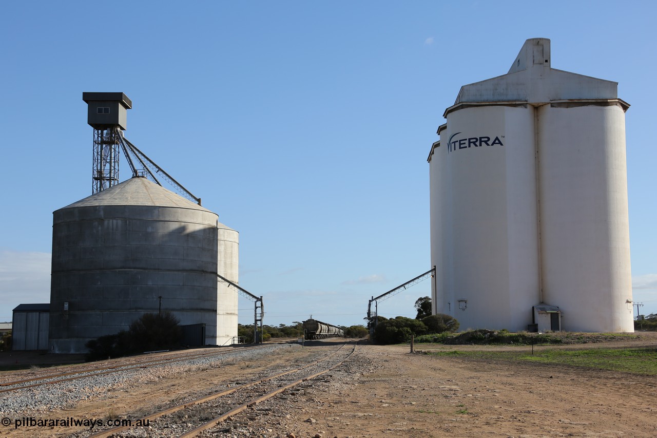 130704 0405
Kyancutta, yard overview looking north with the Ascom silo complex of the left, Mallee shelter visible in the shadow, the 'new' grain loop added in 1970, mainline with loaded grain waggons, the original good siding and the concrete eight cell silo complex. 4th July 2013.
