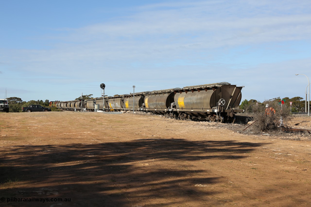 130704 0407
Kyancutta, south bound loaded grain train has stopped here to collect a loaded rack of grain waggons, the second driver has just restored the points for the mainline as the train waits across the Eyre Highway grade crossing and one of only three electric signals on the network, behind EMD 1204 and twin ALCo 830 units 873 and 851. 4th July 2013.
