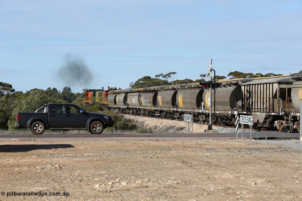 130704 0409
Kyancutta, south bound loaded grain train has stopped here to collect a loaded rack of grain waggons, seen here backing up to re-join the rest of the train on the mainline as it crosses the Eyre Highway grade crossing, behind EMD 1204 and twin ALCo 830 units 873 and 851. 4th July 2013.
