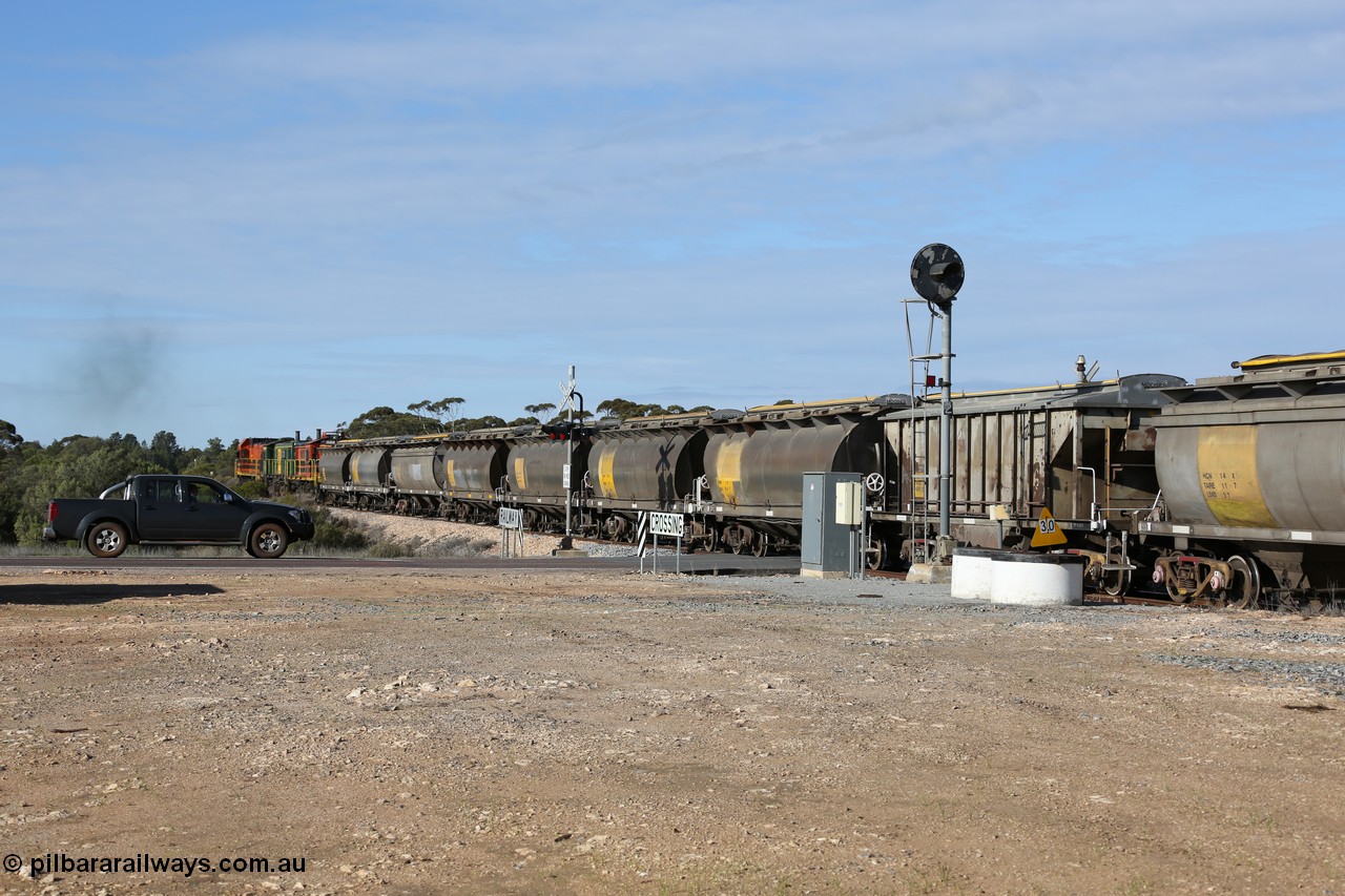 130704 0410
Kyancutta, south bound loaded grain train has stopped here to collect a loaded rack of grain waggons, seen here backing up to re-join the rest of the train on the mainline as it crosses the Eyre Highway grade crossing and one of only three electric signals on the network, behind EMD 1204 and twin ALCo 830 units 873 and 851. 4th July 2013.
