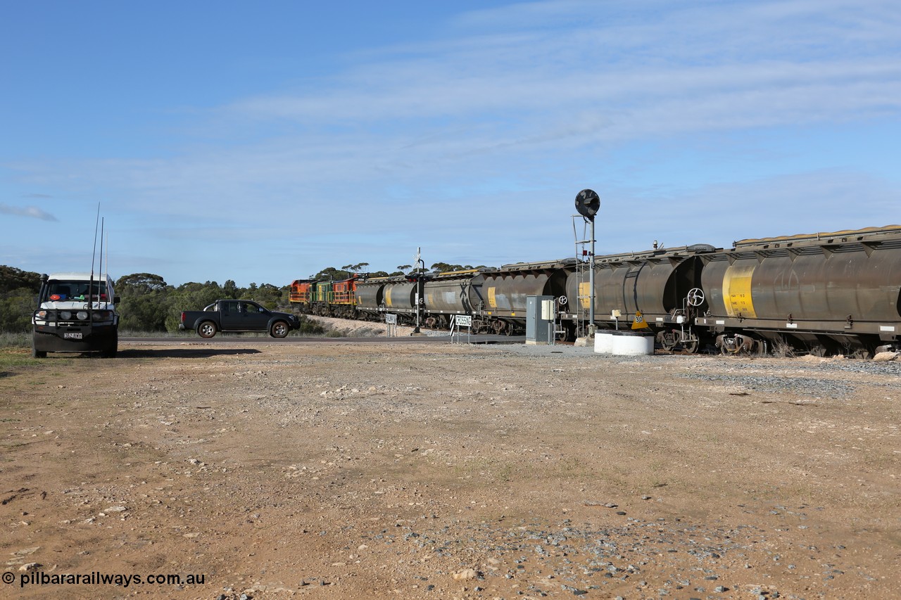 130704 0411
Kyancutta, south bound loaded grain train has stopped here to collect a loaded rack of grain waggons, seen here backing up to re-join the rest of the train on the mainline as it crosses the Eyre Highway grade crossing and one of only three electric signals on the network, behind EMD 1204 and twin ALCo 830 units 873 and 851. 4th July 2013.

