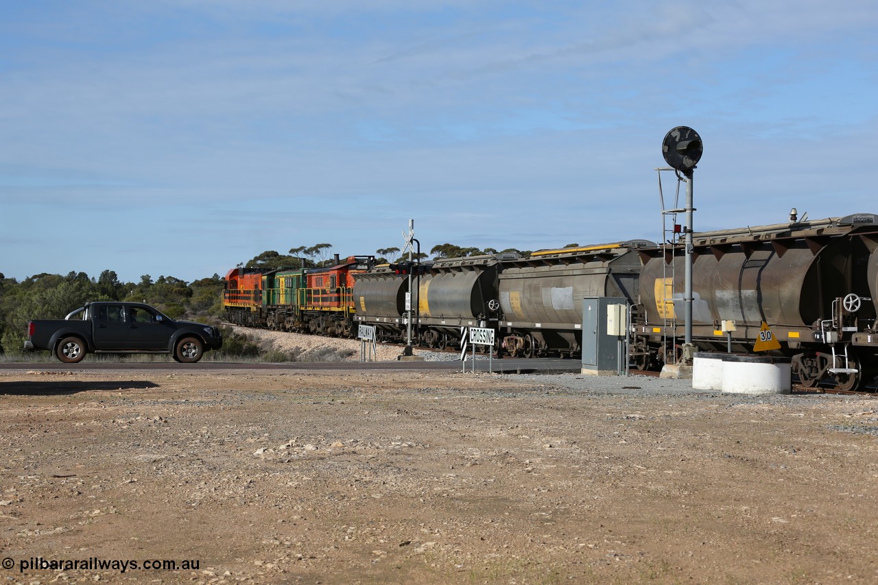 130704 0412
Kyancutta, south bound loaded grain train has stopped here to collect a loaded rack of grain waggons, seen here backing up to re-join the rest of the train on the mainline as it crosses the Eyre Highway grade crossing and one of only three electric signals on the network, behind EMD 1204 and twin ALCo 830 units 873 and 851. 4th July 2013.
