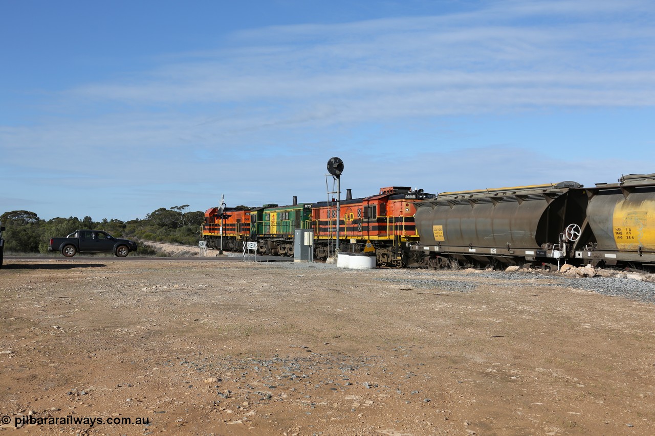 130704 0414
Kyancutta, south bound loaded grain train has stopped here to collect a loaded rack of grain waggons, seen here backing up to re-join the rest of the train on the mainline as it crosses the Eyre Highway grade crossing and one of only three electric signals on the network, behind EMD 1204 and twin ALCo 830 units 873 and 851. 4th July 2013.
