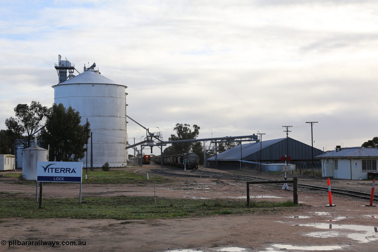 130705 0603
Lock, located at the 148.5 km and originally named Terre when opened in May 1913, later renamed to Lock in December 1921. From the left is the concrete toilet block, Ascom silo complex (Block 5), the train is loading on the grain loop, loaded rake on the mainline, horizontal bunker (Block 4) and the crew barracks. 5th July 2013.
