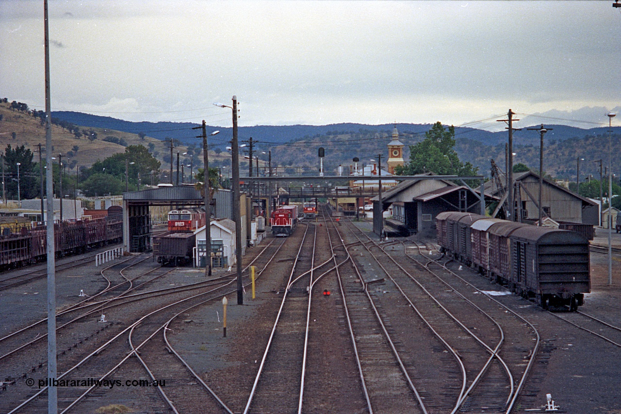 100-01
Albury station yard overview looking south, from Wilson Street footbridge, loco shed with 81 class, 48 class yard shunter, 81 class beside station with north bound goods train, goods sheds at right with louvre vans. [url=https://goo.gl/maps/nngpTA37VQekQpCt7]Geodata[/url].
Keywords: 81-class;48-class;
