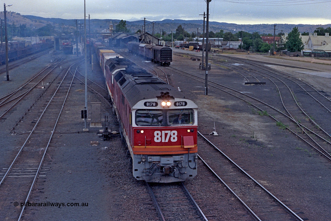 100-03
Albury station yard overview looking south, from Wilson Street footbridge, NSWSRA standard gauge 81 class 8178 Clyde Engineering EMD model JT26C-2SS serial 85-1097 double heading with a sister 81 class, both in candy livery, Sydney bound goods, 2 lever ground frame beside loco. [url=https://goo.gl/maps/nngpTA37VQekQpCt7]Geodata[/url].
Keywords: 81-class;8178;Clyde-Engineering-Kelso-NSW;EMD;JT26C-2SS;85-1097;