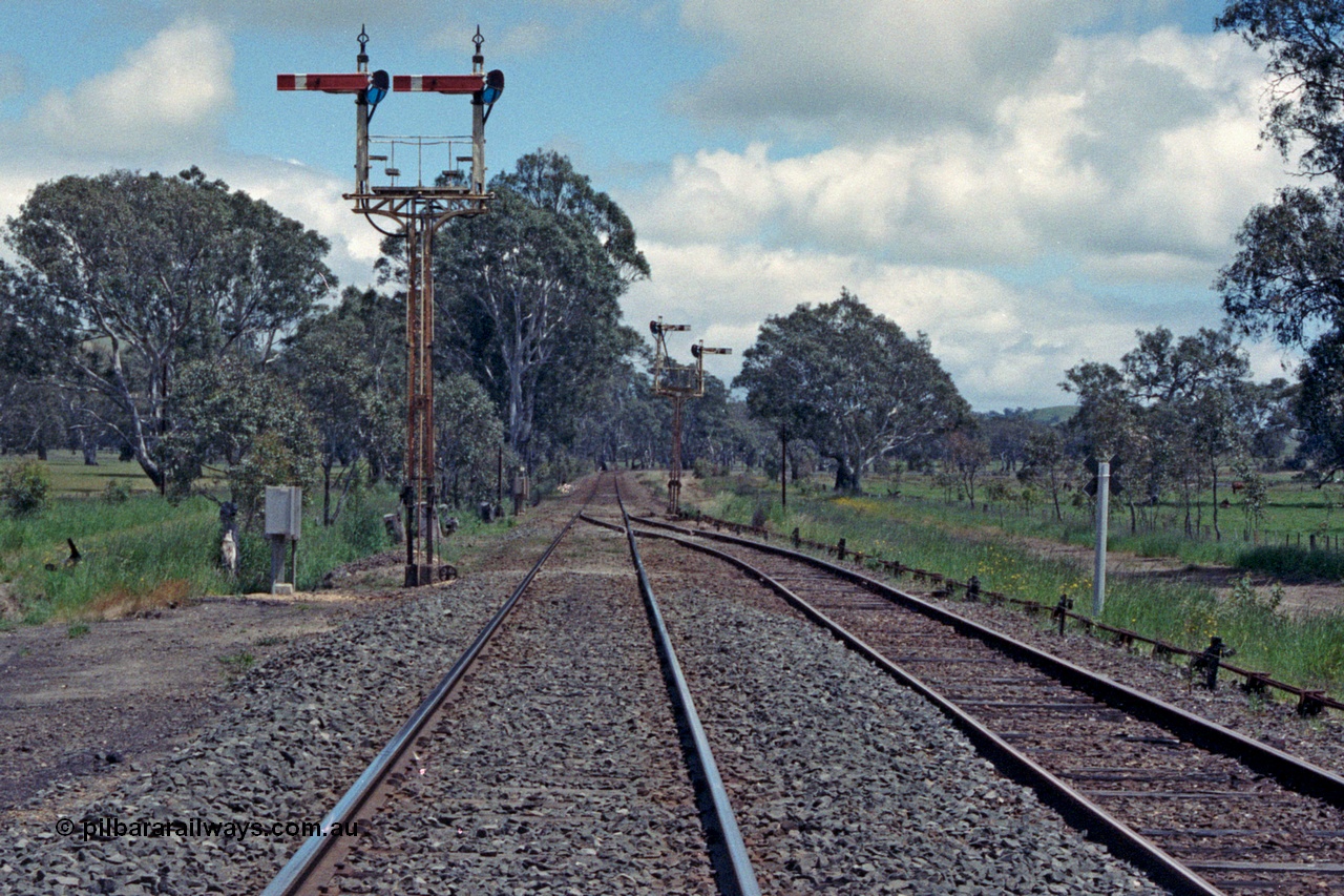 104-05
Buangor crossing loop, yard view looking west, mechanical somersault semaphore signal post 5, Down Home, facing camera and mechanical somersault semaphore signal post 6, Up Home, in the distance facing west, point rodding following No.1 Rd to the points.
