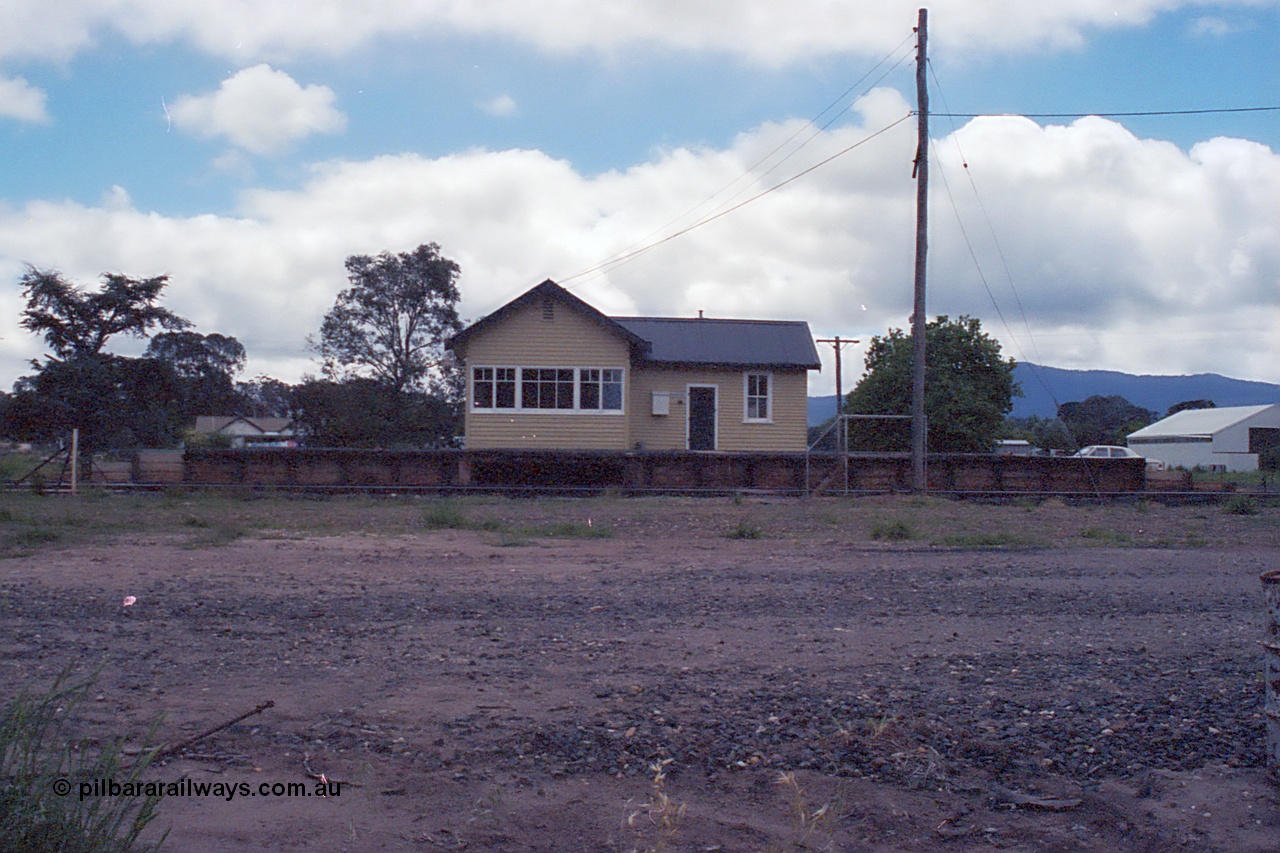 104-13
Buangor station building overview, front elevation of building, signal box and platform, very dark.
