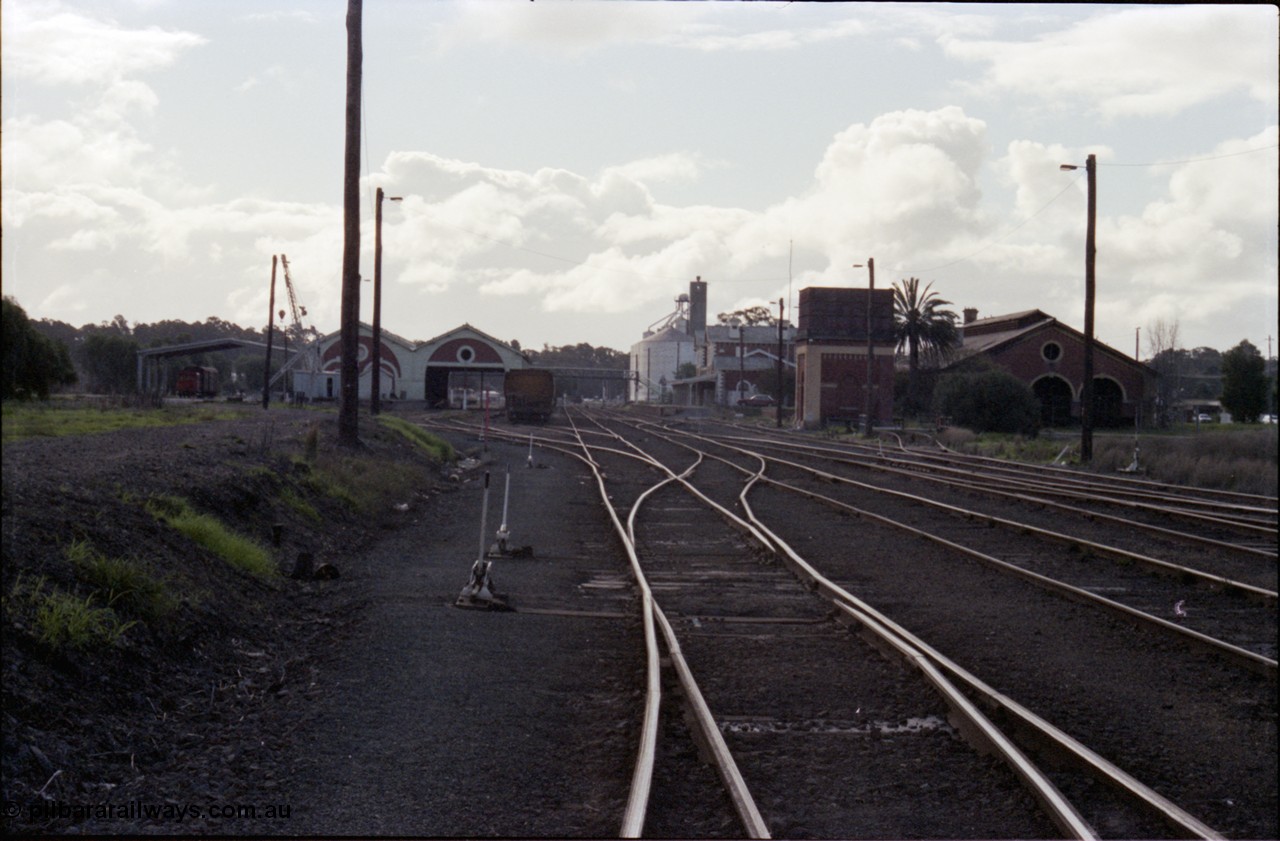 107-27
Echuca station yard overview, looking north from Sidings A, Freightgate canopy, yard crane. goods shed, station building, water tower and loco shed.
