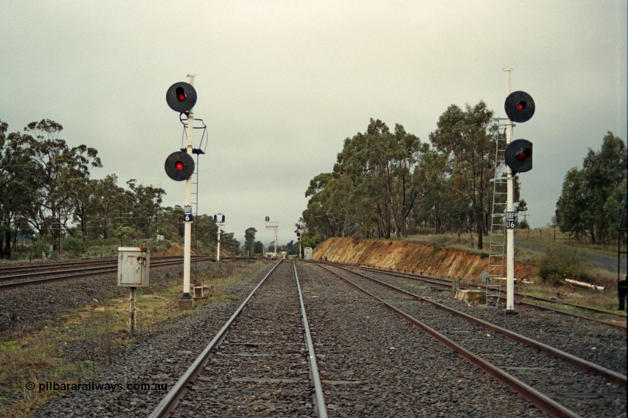 109-07
Broadford Loop, standard gauge, looking north, new searchlight signal posts BRF/6 and BRF/U6 on the right, former signal gantry footings behind posts, not BRF U6 lower target has been trimmed to allow gauge clearance on the ballast loading siding on the right, broad gauge mainline tracks to the left

