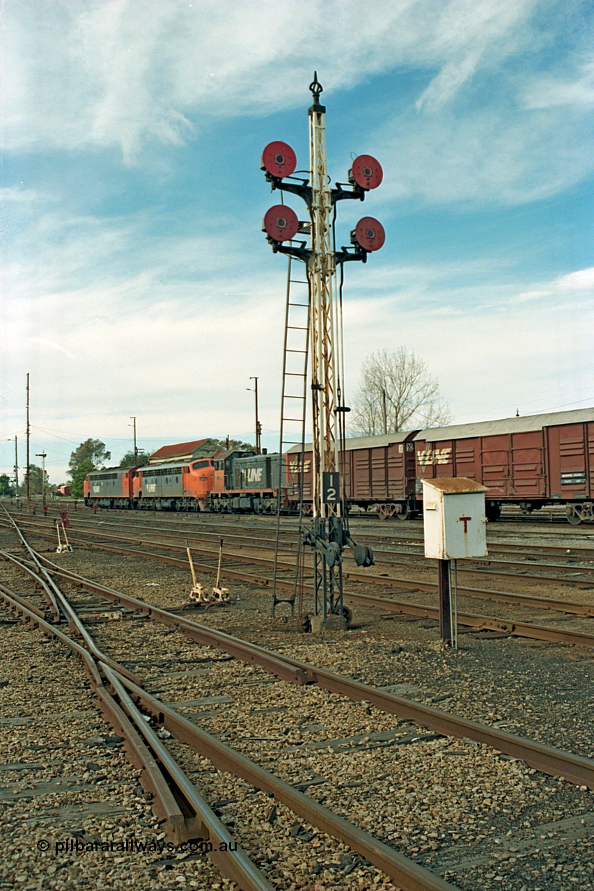 110-08
Benalla yard view, quad disc signal post 12 looking north, broad gauge V/Line S class S 302 'Edward Henty' Clyde Engineering EMD model A7 serial 57-166, B class B 64 Clyde Engineering EMD model ML2 serial ML2-5 and V/Line T class loco T 403 with serial 67-498 a Clyde Engineering Granville NSW built EMD model G18B, stabled down Wodonga goods train 9303, point levers, telephone cabinet for talking to signal box.
Keywords: S-class;S302;Clyde-Engineering-Granville-NSW;EMD;A7;57-166;bulldog;B-class;B64;ML2;ML2-5;T-class;T403;G18B;67-498;