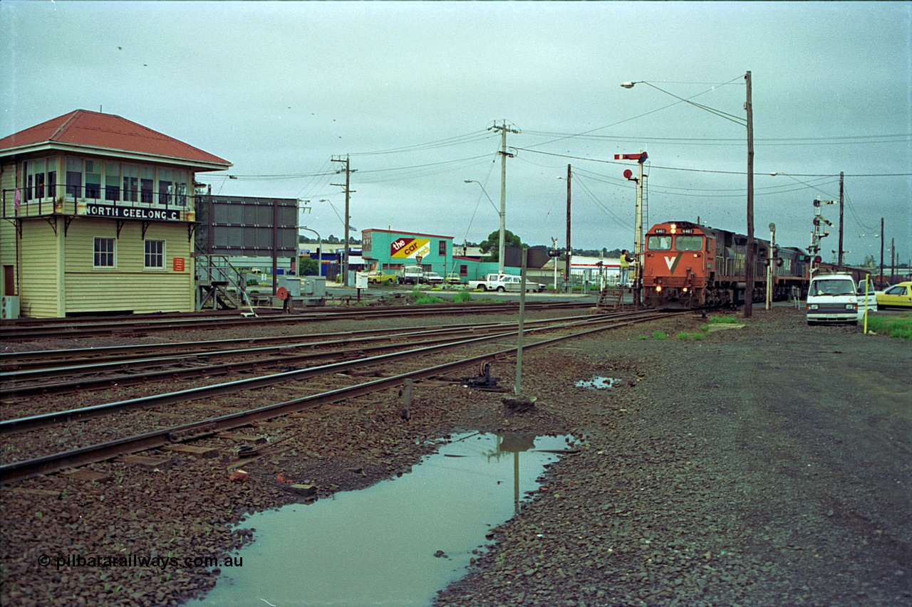 111-03
North Geelong C Box, V/Line broad gauge locos N class N 461 'City of Ararat' Clyde Engineering EMD model JT22HC-2 serial 86-1190 and X class X 47 Clyde Engineering EMD model G26C serial 75-794 pick up the electric staff for the grain loop, signaller on the staff exchange platform, signal box, ground dwarf disc signal, semaphore signal posts.
Keywords: N-class;N461;Clyde-Engineering-Somerton-Victoria;EMD;JT22HC-2;86-1190;
