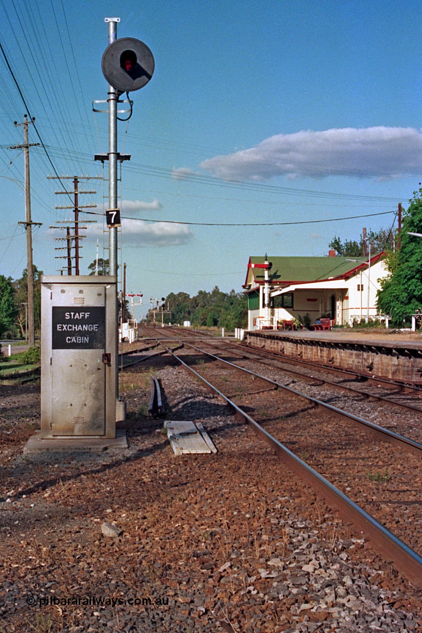112-06
Violet Town broad gauge track view looking north, station overview, staff exchange cabin and cover for ground apparatus, cabin used when signal box is switched out, searchlight signal post 7, station building and signal bay, semaphore signal post 9 on platform, March 1994.
