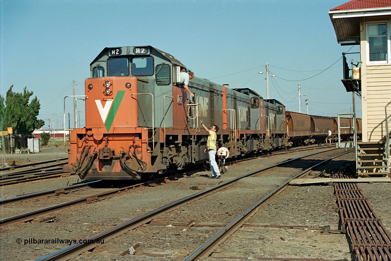 112-31
North Geelong C Box, V/Line broad gauge H class locos H 2 Clyde Engineering EMD model G18B serial 68-630, H 5 serial 68-632 and H 4 serial 68-633 shunt empty an grain train rake back into North Geelong yard, past C Box as the driver surrenders the staff to the signaller for the Grain Loop, safeworking, point rodding.
Keywords: H-class;H2;Clyde-Engineering-Granville-NSW;EMD;G18B;68-630;H5;68-632;H4;68-633;