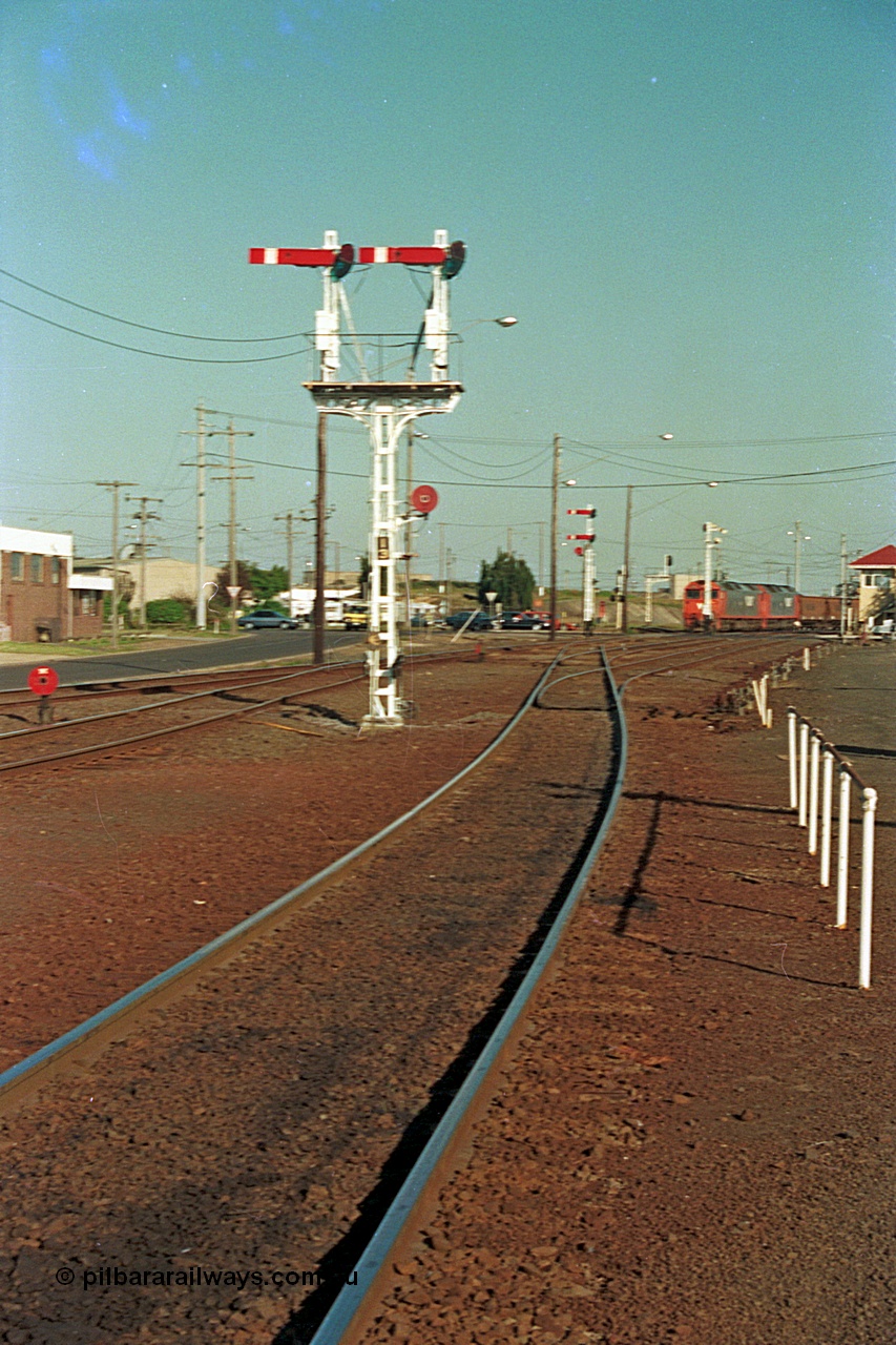 112-37
North Geelong C Box, looking east, semaphore signal post 13 freshly repainted, standing on broad gauge mainline to Gheringhap, grain arrivals at left, in the distance V/Line G class G 529 Clyde Engineering EMD model JT26C-2SS serial 88-1259 leads a departing grain train, off focus.
Keywords: G-class;G529;Clyde-Engineering-Somerton-Victoria;EMD;JT26C-2SS;88-1259;