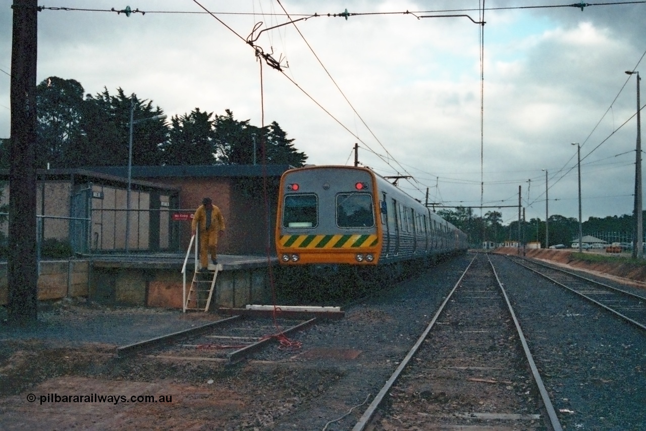 115-07
Hurstbridge, The Met broad gauge six car Comeng electric suburban train, yard view looking south, overhead grounded, stabling sidings, station platform, concrete ablution block.
