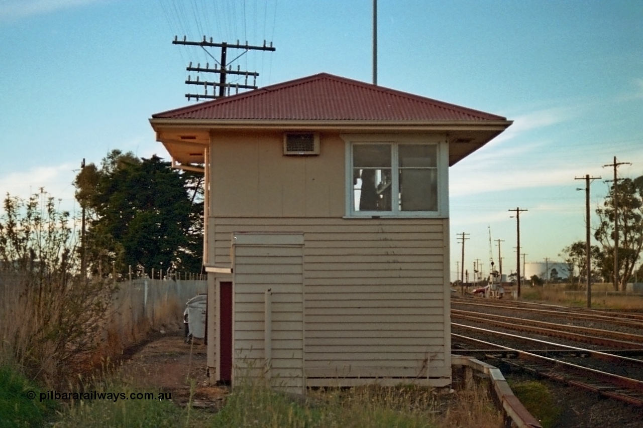 115-11
Somerton signal box, RHS elevation, looking north, grade crossing for Somerton Road visible, toilet in front of elevation, broad gauge lines in front of box with crossover to sidings visible crossing standard gauge line.
