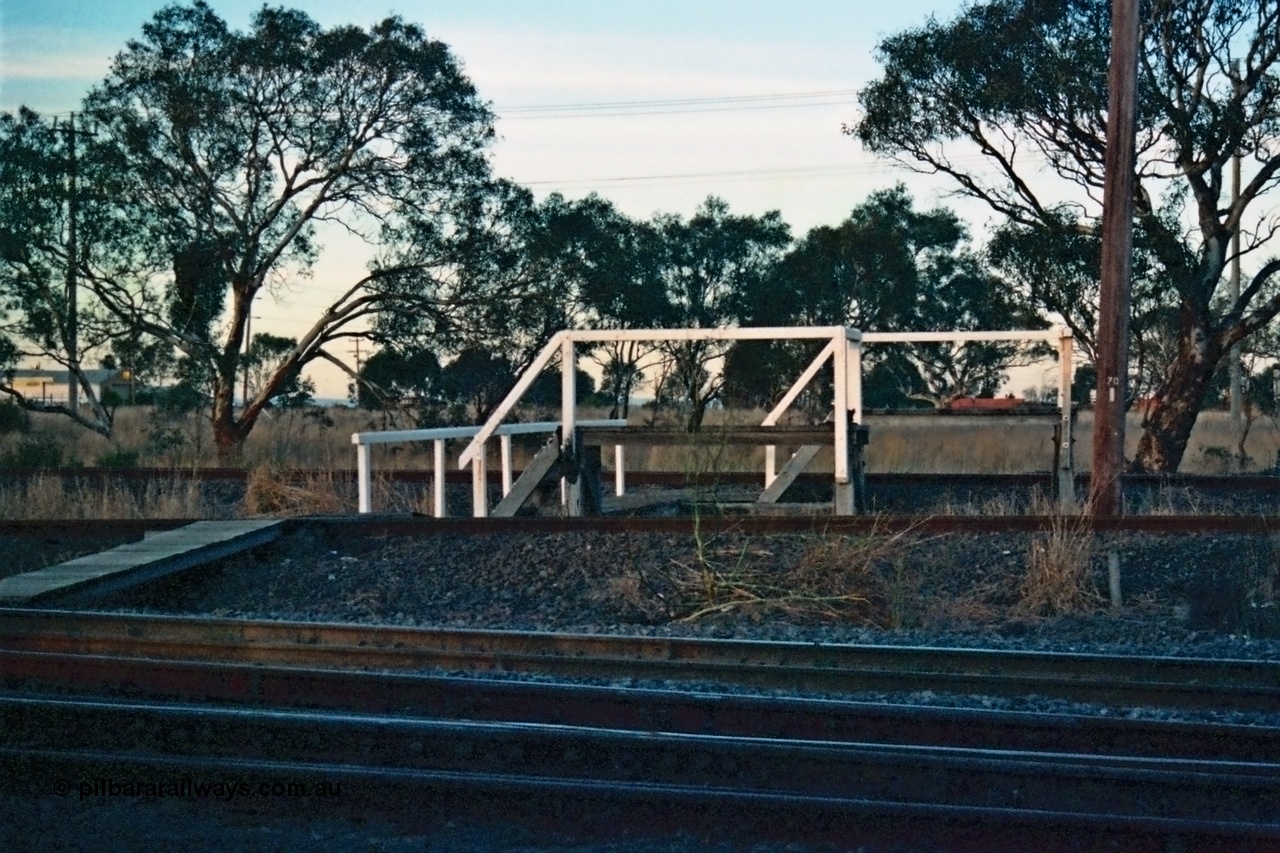 115-12
Somerton, staff exchange platforms for Ford's Siding / Upfield line, far platform for the broad gauge, with the standard gauge using the near platform, lines converge to dual gauge around curve, looking across the North East broad and standard gauge running lines.
