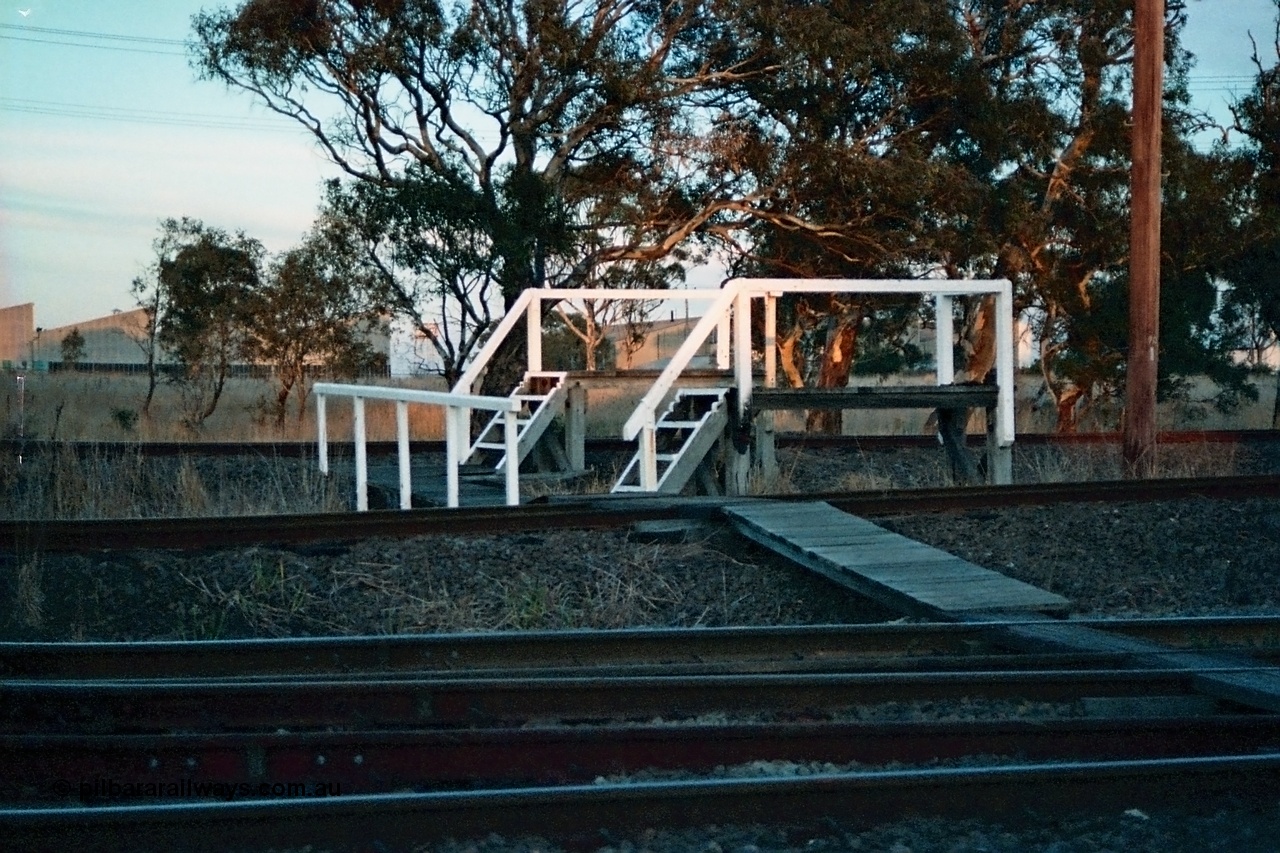 115-17
Somerton, staff exchange platforms for Ford's Siding / Upfield line, far platform for the broad gauge, with the standard gauge using the near platform, lines converge to dual gauge around curve, looking across the North East broad and standard gauge running lines.
