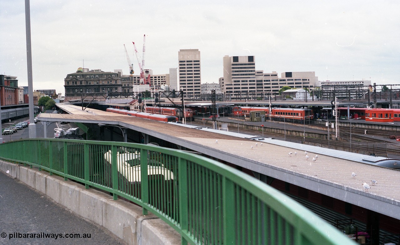 116-05
Spencer Street Station, view looking east from flyover, platform No.2 below with standard gauge car dock, South End Signal Box visible on Platform No's 3 and 4, V/Line N sets, A and N class locos, Crown Casino in the background behind the Spencer Street V/Line head office building, platform No.1 at far left.

