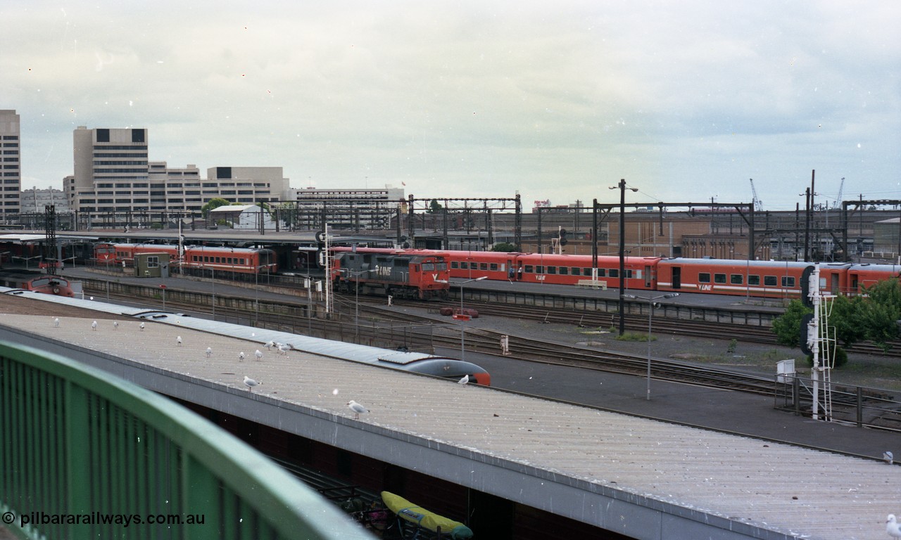116-12
Spencer Street Station, view looking south from flyover, V/Line broad gauge passenger platforms, N class N 457 'City of Mildura' Clyde Engineering EMD model JT22HC-2 serial 85-1225 shunts away from an N set, behind it is a Victorian Railways 'Tea Cup' with V/Line liveried N set coupled to current V/Line liveried N set.
Keywords: N-class;N457;Clyde-Engineering-Somerton-Victoria;EMD;JT22HC-2;85-1225;