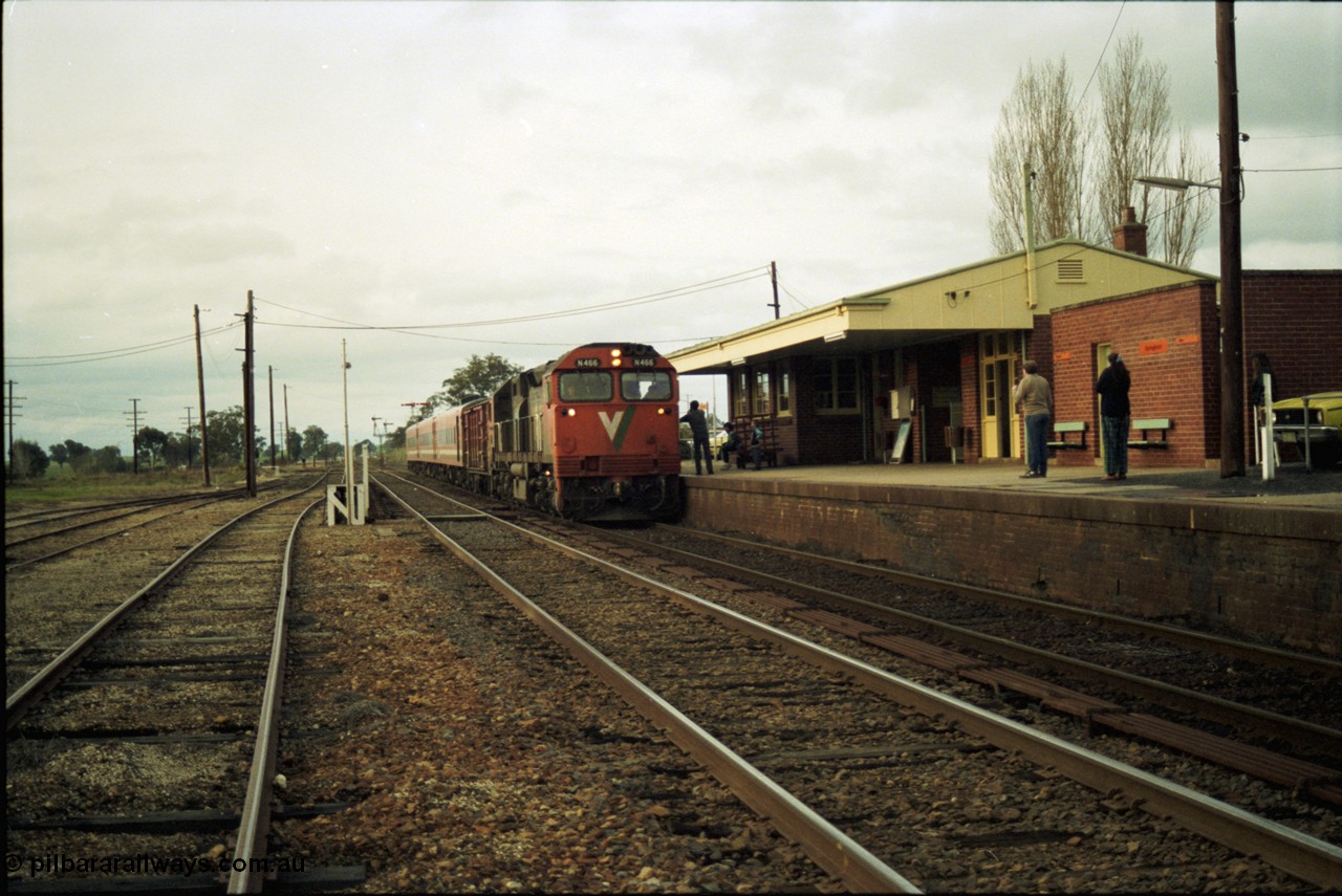 117-11
Springhurst, V/Line N class N 466 'City of Warrnambool' Clyde Engineering EMD model JT22HC-2 serial 86-1195 arrives with an N set and D van on an up Albury passenger train as the driver and signaller exchanges electric staffs, yard overview, station building and platform.
Keywords: N-class;N466;Clyde-Engineering-Somerton-Victoria;EMD;JT22HC-2;86-1195;