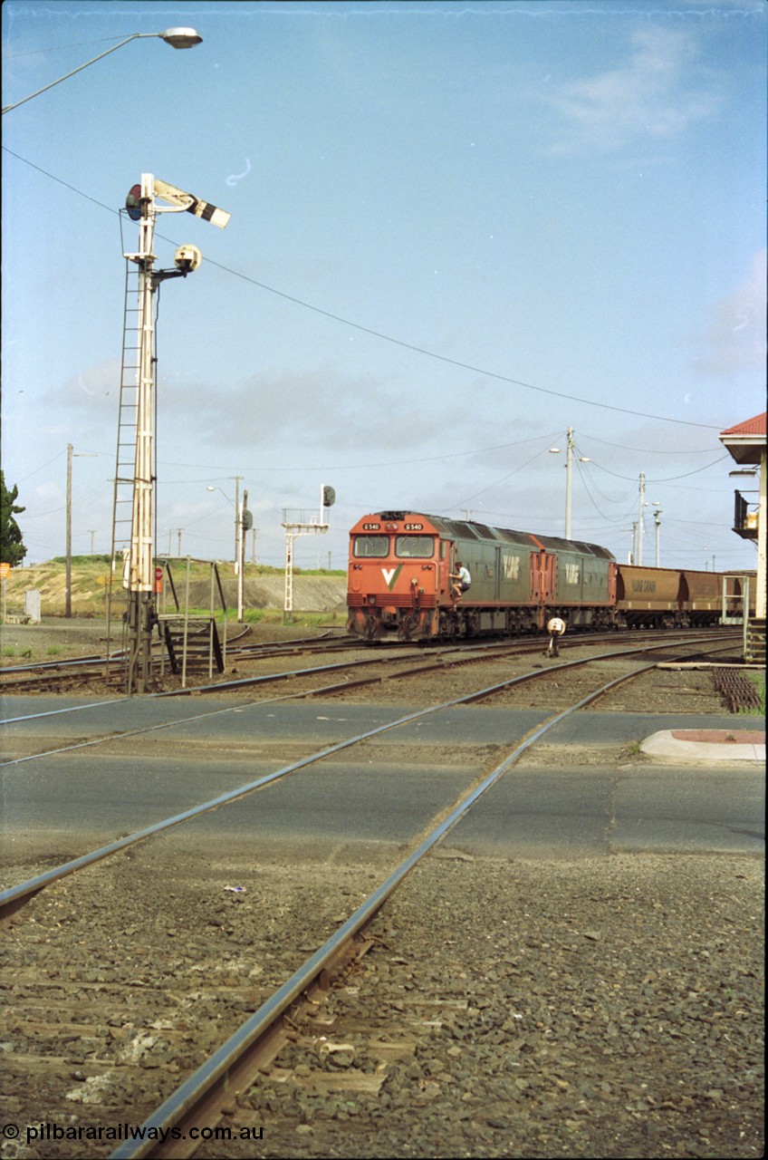 119-11
North Geelong C Box, V/Line broad gauge G classes G 540 Clyde Engineering EMD model JT26C-2SS serial 89-1273 and sister depart with down empty grain train 9125, looking across Separation Street, semaphore signal post 16 is pulled off for move, grade crossing, 2nd person climbing aboard with staff.
Keywords: G-class;G540;Clyde-Engineering-Somerton-Victoria;EMD;JT26C-2SS;89-1273;