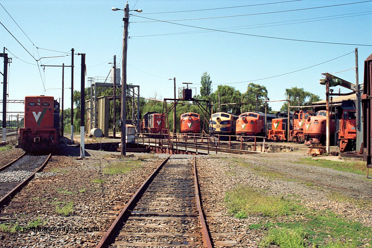 122-14
Traralgon loco depot overview from eastern end, V/Line broad gauge locos are all Clyde Engineering EMD models; T class T 407 model G18B serial 68-623, T class T 396 model G8B serial 65-426, A class A 77 model AAT22C-2R serial 83-1181 rebuilt from B class B 77 model ML2 serial ML2-18, B class B 75 serial ML2-16 still in VR livery, A class A 81 serial 85-1189 rebuilt from B class B 81 serial ML2-22, T class T 381 model G8B serial 64-336, Y class Y 168 model G6B serial 68-588, A class A 78 serial 84-1185 rebuilt from B class B 78 serial ML2-19 and G class G 512 model JT26C-2SS serial 84-1240.
