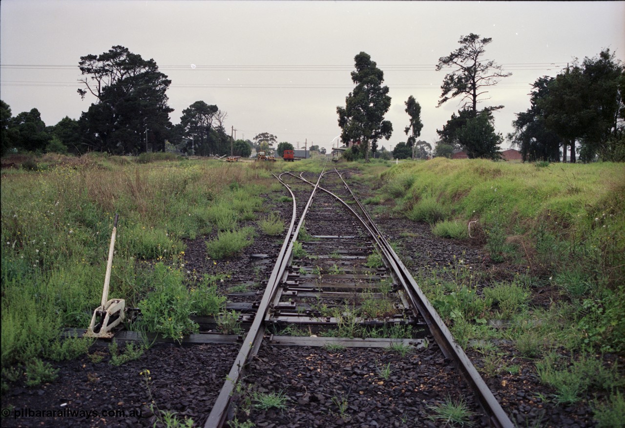123-2-05
Maffra station yard overview, looking from Tinamba, points and lever, rail tractor in the background, station building further on, factories on the right.
