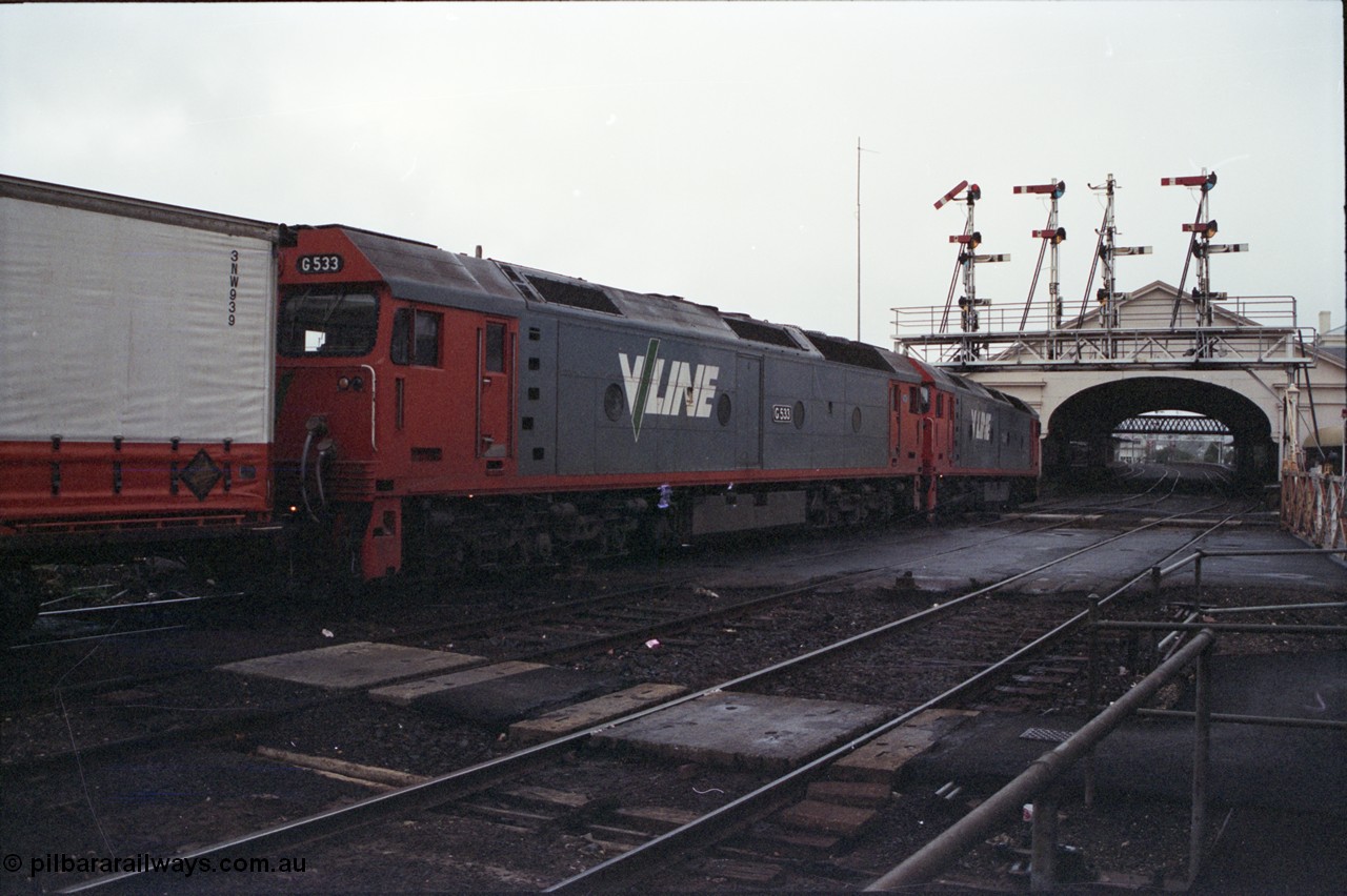 123-2-36
Ballarat station and canopy, semaphore signal gantry, Lydiard Street grade crossing, V/Line broad gauge G classes G 528 Clyde Engineering EMD model JT26C-2SS serial 88-1258 and G 533 Clyde Engineering EMD model JT26C-2SS serial 88-1263 with up Adelaide goods train 9150.
Keywords: G-class;G528;Clyde-Engineering-Somerton-Victoria;EMD;JT26C-2SS;88-1258;