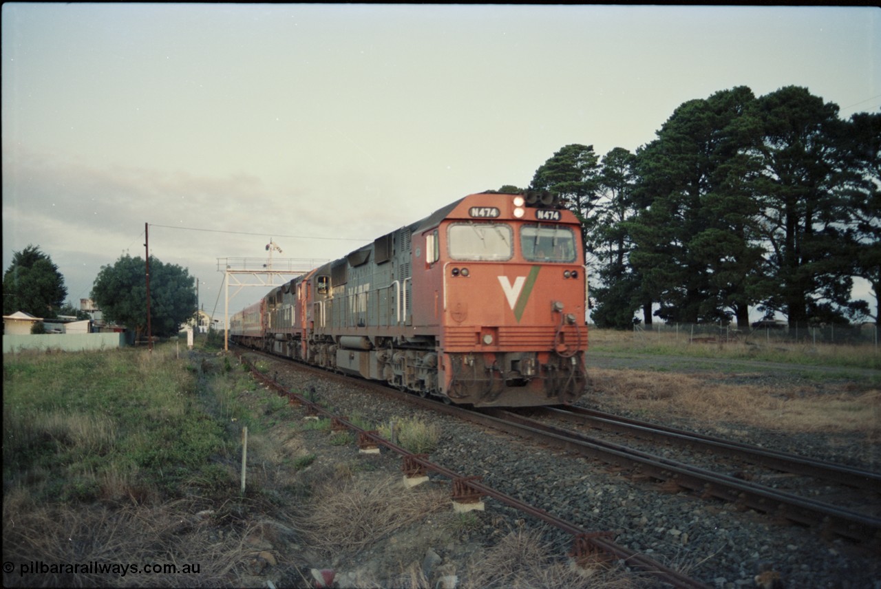 125-05
Ballan broad gauge V/Line N class N 474 'City of Traralgon' Clyde Engineering EMD model JT22HC-2 serial 87-1203 with another N class and N set on a down passenger train departing, early evening shot, signal gantry.
Keywords: N-class;N474;Clyde-Engineering-Somerton-Victoria;EMD;JT22HC-2;87-1203;