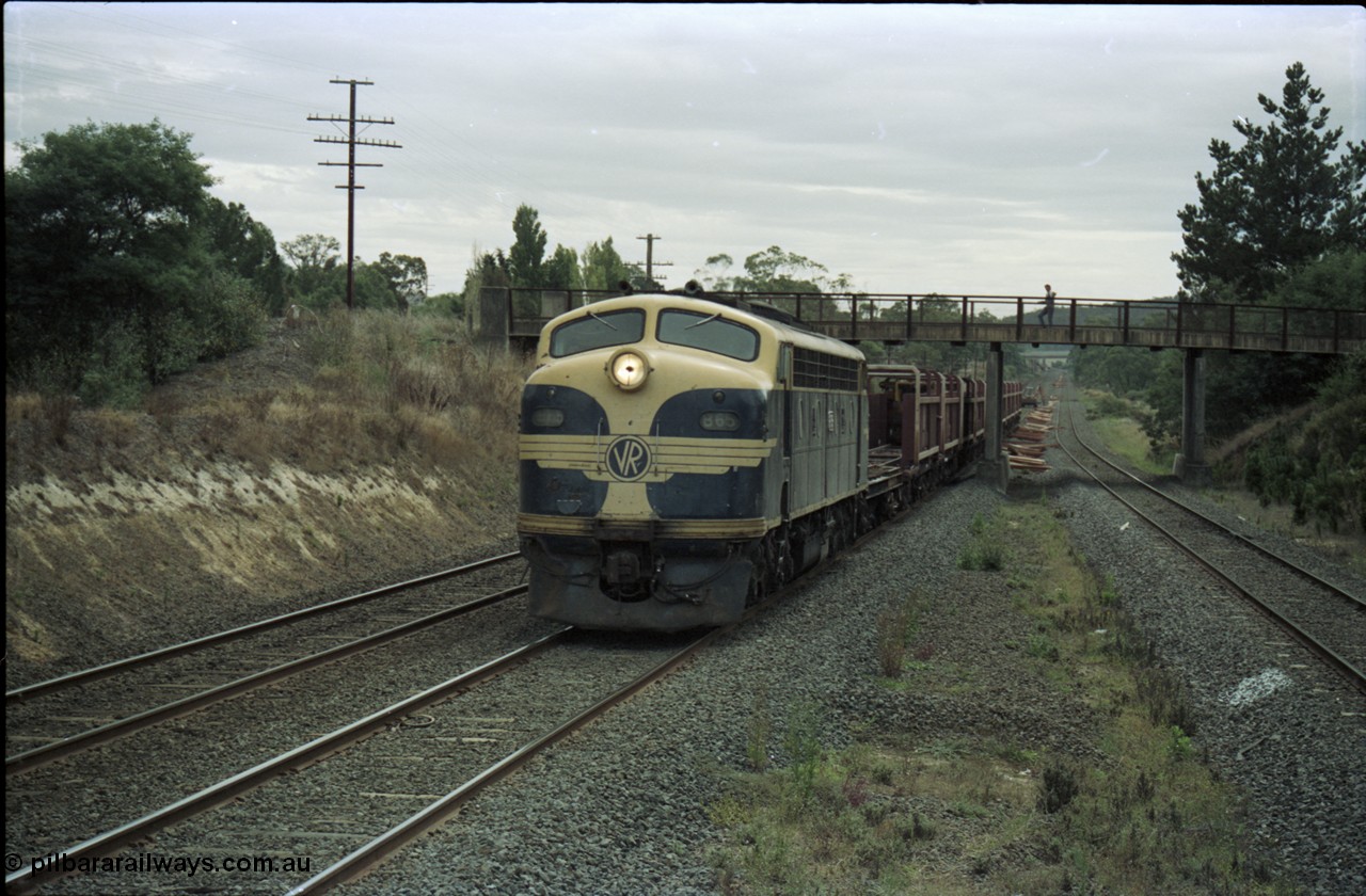 125-15
Wandong passing under Kilmore - Wandong Rd, V/Line broad gauge B class Clyde Engineering EMD model ML2 serial ML2-6 still in Victorian Railways livery leads a sleeper discharge train on the up broad gauge line, discharging sleepers.
Keywords: B-class;B65;Clyde-Engineering-Granville-NSW;EMD;ML2;ML2-6;bulldog;