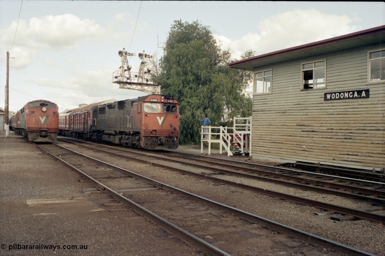 127-09
Wodonga broad gauge V/Line N class N 468 'City of Bairnsdale' Clyde Engineering EMD model JT22HC-2 serial 86-1197 leads the afternoon up Albury passenger train past stabled A 70 Clyde Engineering EMD model AAT22C-2R serial 84-1187 rebuilt from B 70 Clyde Engineering EMD model ML2 serial ML2-11, as the Wodonga signaller offers up the electric staff for the section to Springhurst to the driver.
Keywords: N-class;N468;Clyde-Engineering-Somerton-Victoria;EMD;JT22HC-2;86-1197;