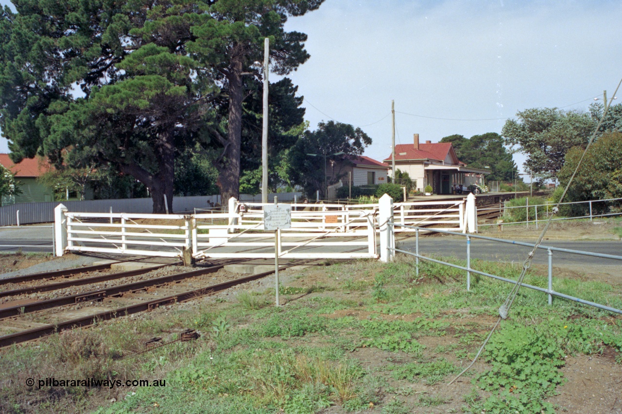 128-17
Gisborne, Gisborne Road grade crossing non-interlocked swing gates, station building in the background.
