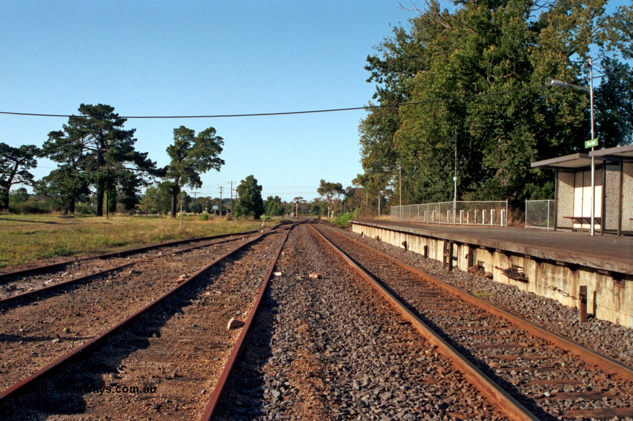 129-1-17
Baxter, station yard overview, looking towards Somerville, station platform and bus type concrete shelter, signal wires visible exiting platform coping, off focus.
