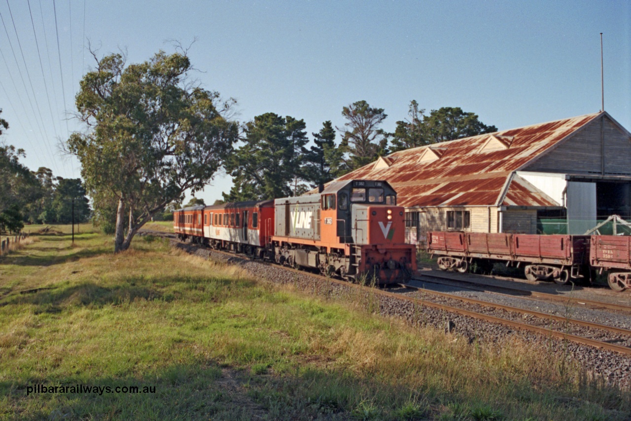 129-1-23
Somerville, broad gauge V/Line T class T 382 Clyde Engineering EMD model G8B serial 64-337 arriving with up Stony Point passenger service consisting of two MTH class trailers, VZOA type bogie dirty ballast waggon VZOA 231, old cool stores in background.
Keywords: T-class;T382;Clyde-Engineering-Granville-NSW;EMD;G8B;64-337;MTH-class;VZOA-type;