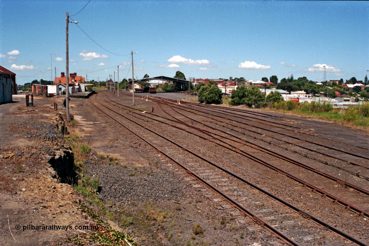129-2-21
Korumburra station yard overview looking down direction, shows former Works Depot siding removed from alongside embankment, Freightgate canopy and overview of yard.
