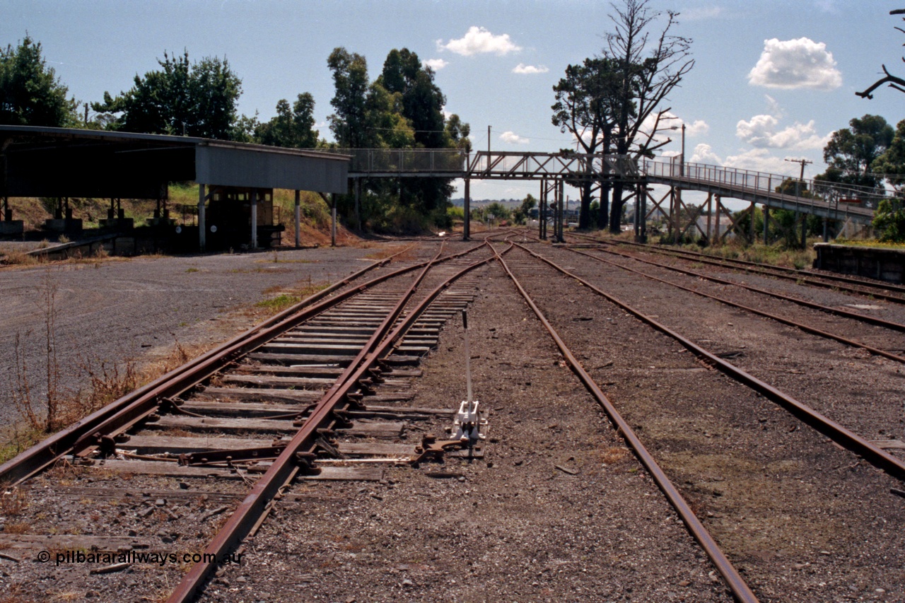 129-2-29
Leongatha yard overview, looking towards Melbourne, footbridge, Victorian Railways liveried RT class rail tractor RT 39 under cover, points and point lever.
