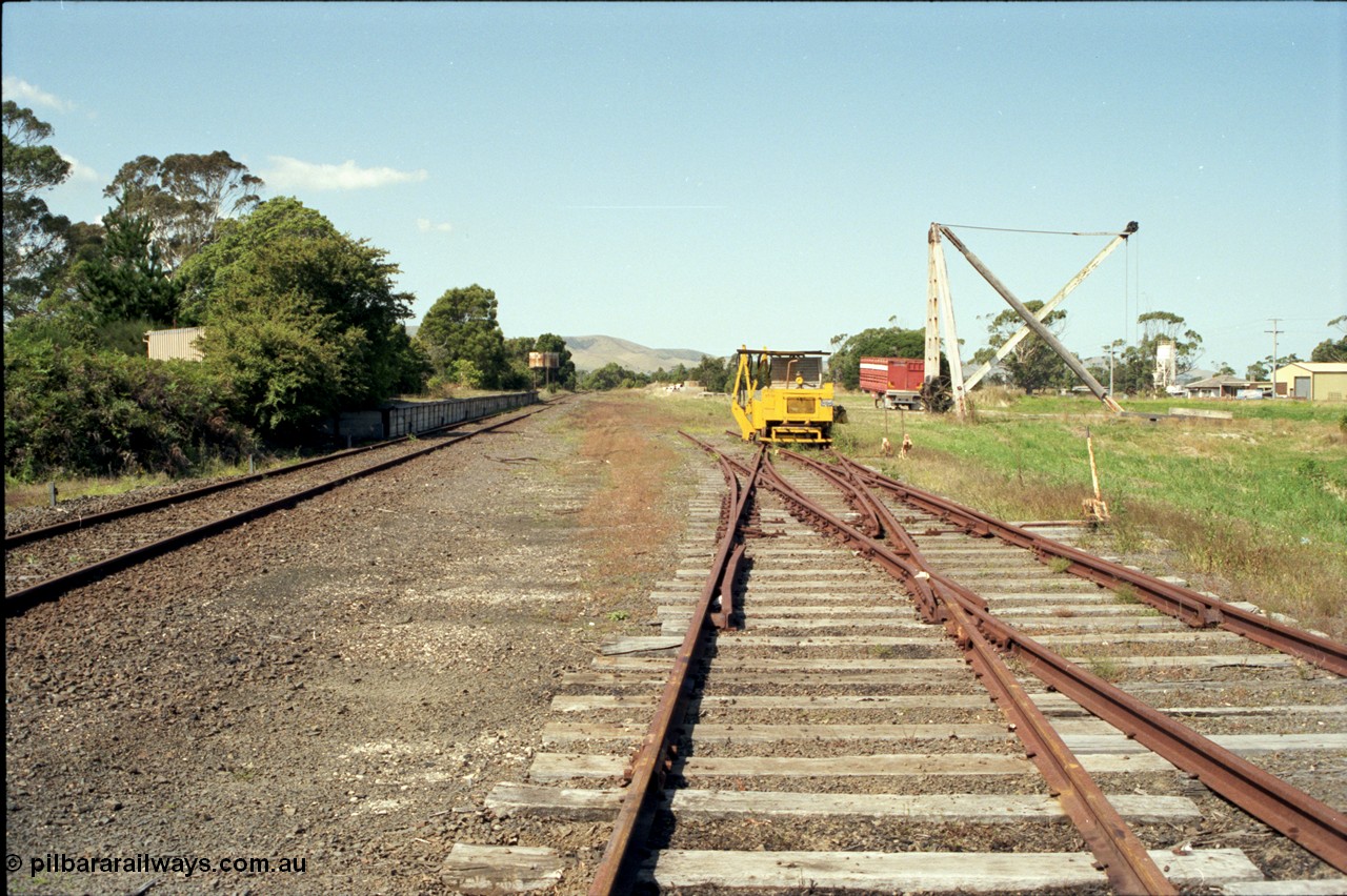 129-3-03
Foster yard overview, Melbourne end looking towards Toora, sleeper inserting machine, timber derrick crane, tracks removed, double compound points and levers.
