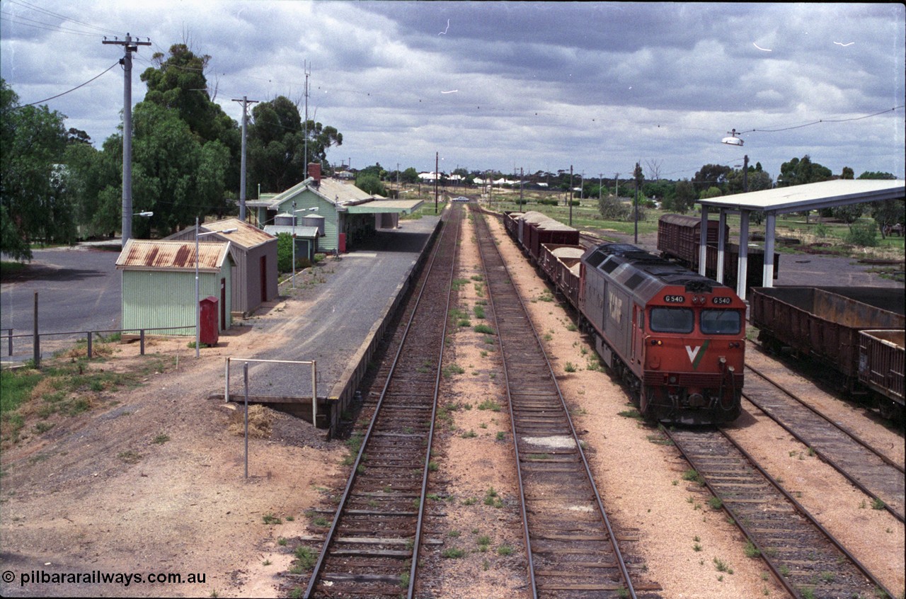 132-04
Ouyen station overview, broad gauge V/Line G class G 540 Clyde Engineering EMD model JT26C-2SS serial 89-1273 with stabled up gypsum train 9138, looking south from footbridge, station building and platform, Freightgate canopy with empty open bogie waggons.
Keywords: G-class;G540;Clyde-Engineering-Somerton-Victoria;EMD;JT26C-2SS;89-1273;