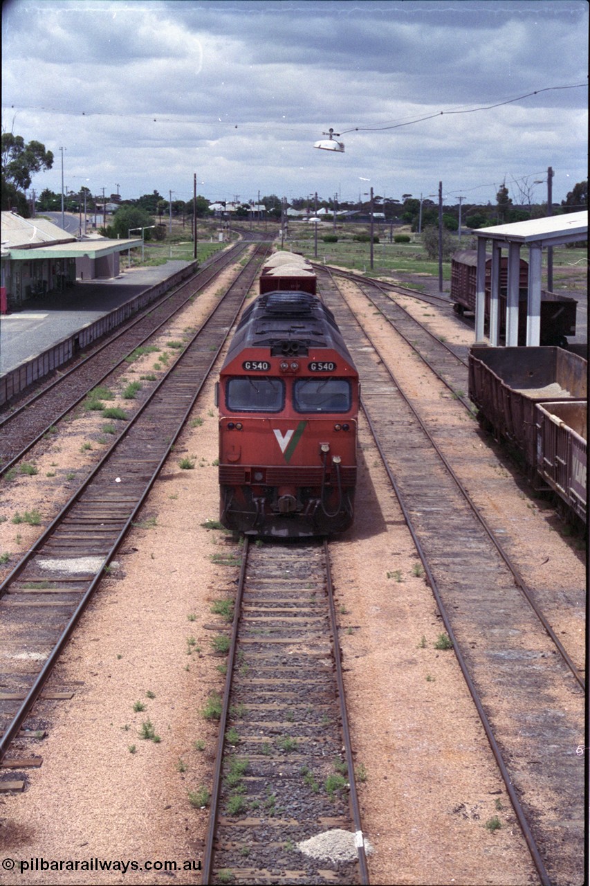 132-05
Ouyen station overview, broad gauge V/Line G class G 540 Clyde Engineering EMD model JT26C-2SS serial 89-1273 with stabled up gypsum train 9138, looking south from footbridge, station building and platform, Freightgate canopy.
Keywords: G-class;G540;Clyde-Engineering-Somerton-Victoria;EMD;JT26C-2SS;89-1273;